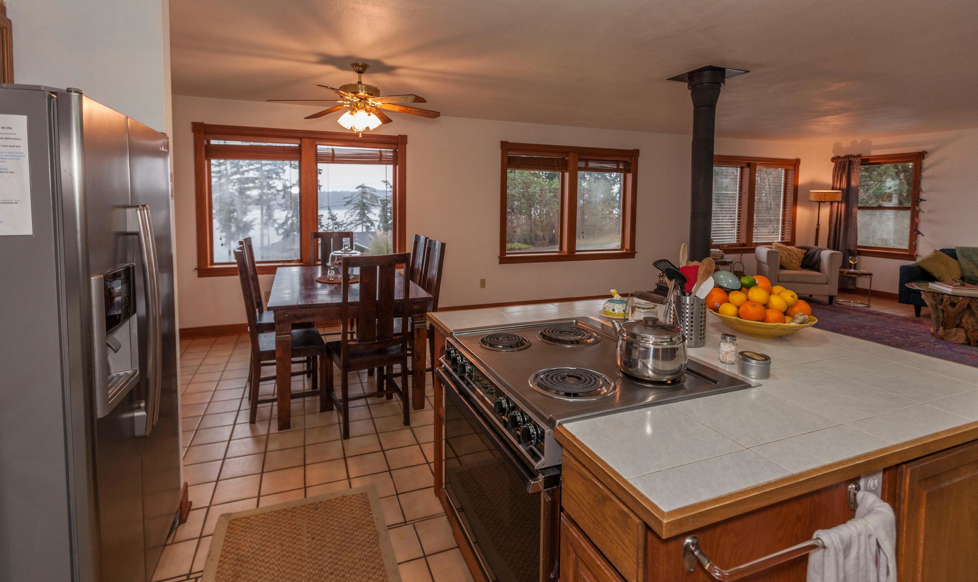 A modern kitchen with a central island, a stove, and a refrigerator.