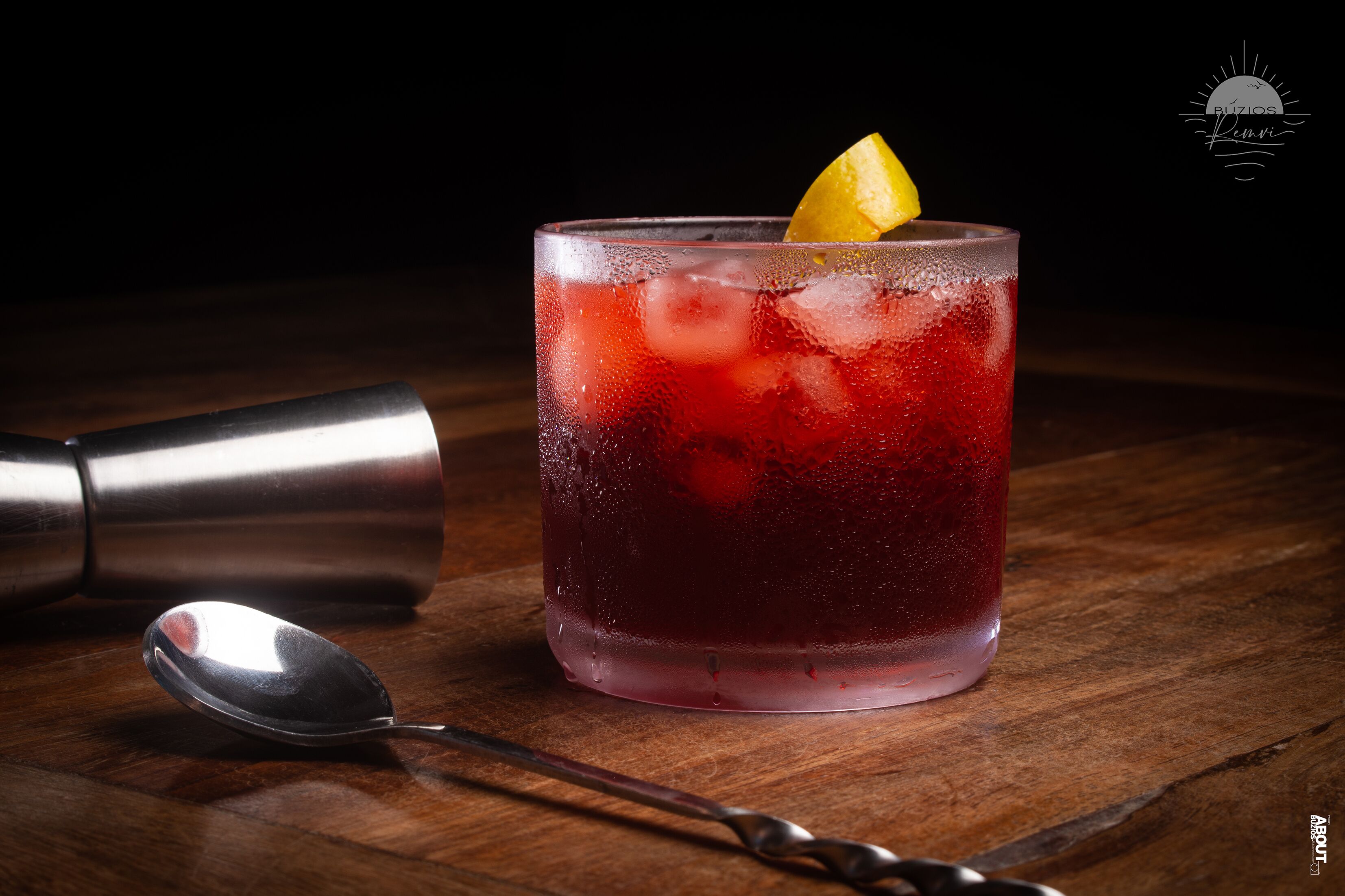 A cocktail glass with a lemon garnish on a wooden surface.