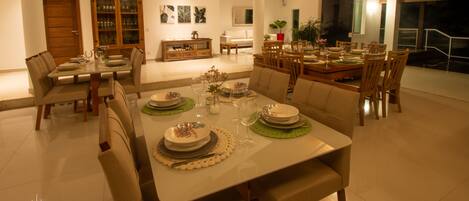 A spacious dining area with a large table set for a meal, surrounded by comfortable seating.