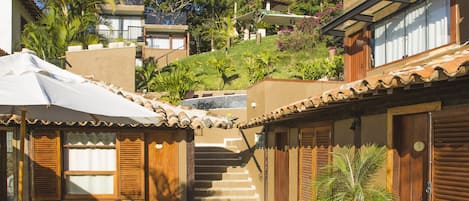 A courtyard with a pool, outdoor seating, and a staircase leading to a building.