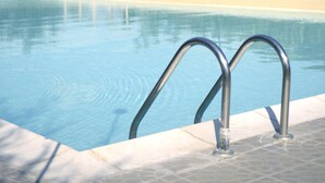 A swimming pool with metal railings and a tiled edge. - Bio Agriturismo Valle dei Calanchi (Castiglione in Teverina)