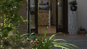 A building entrance with a hanging flower basket, potted plants, and a visible door. - Bio Agriturismo Valle dei Calanchi (Castiglione in Teverina)