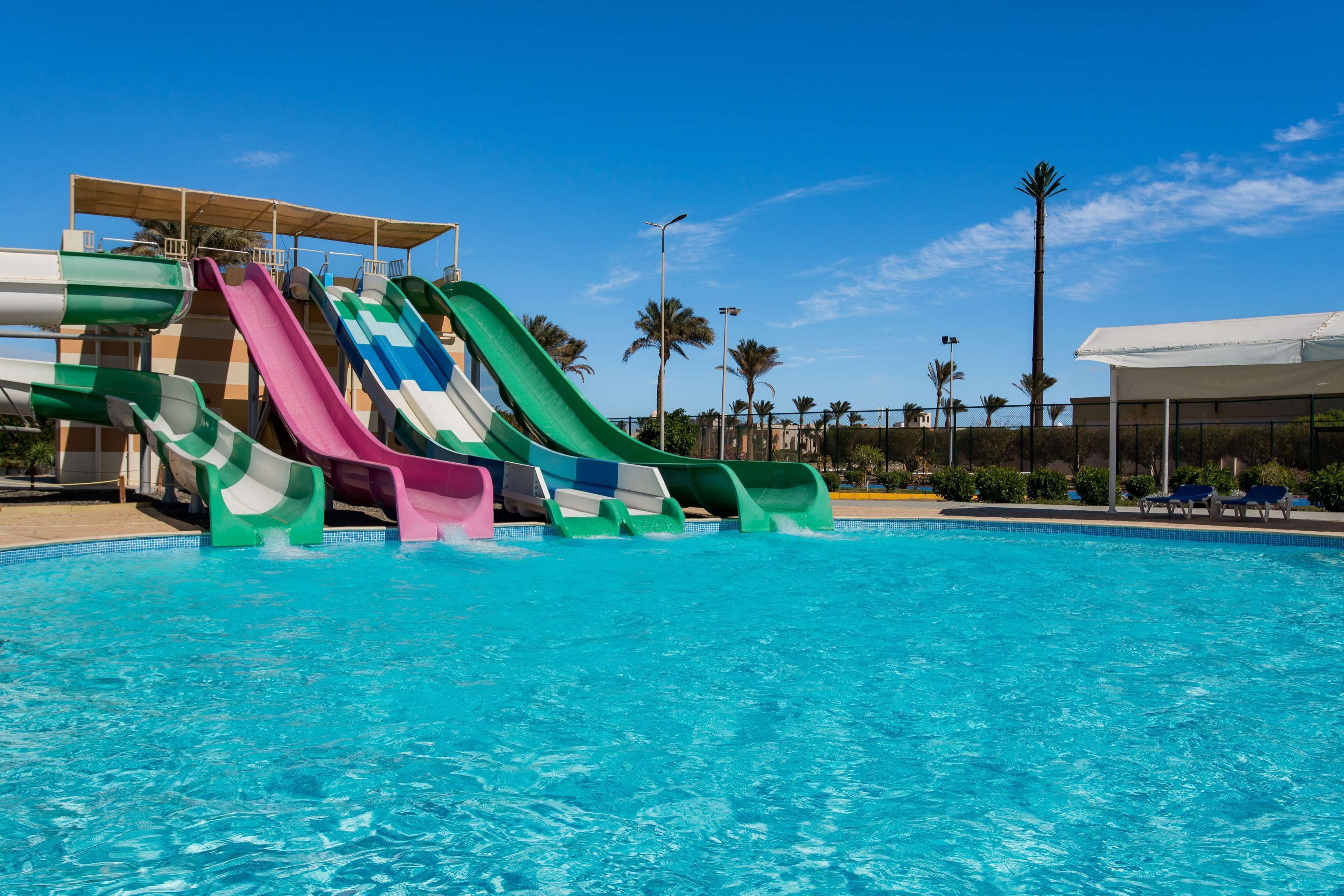 Una piscina con toboganes y una zona cubierta.