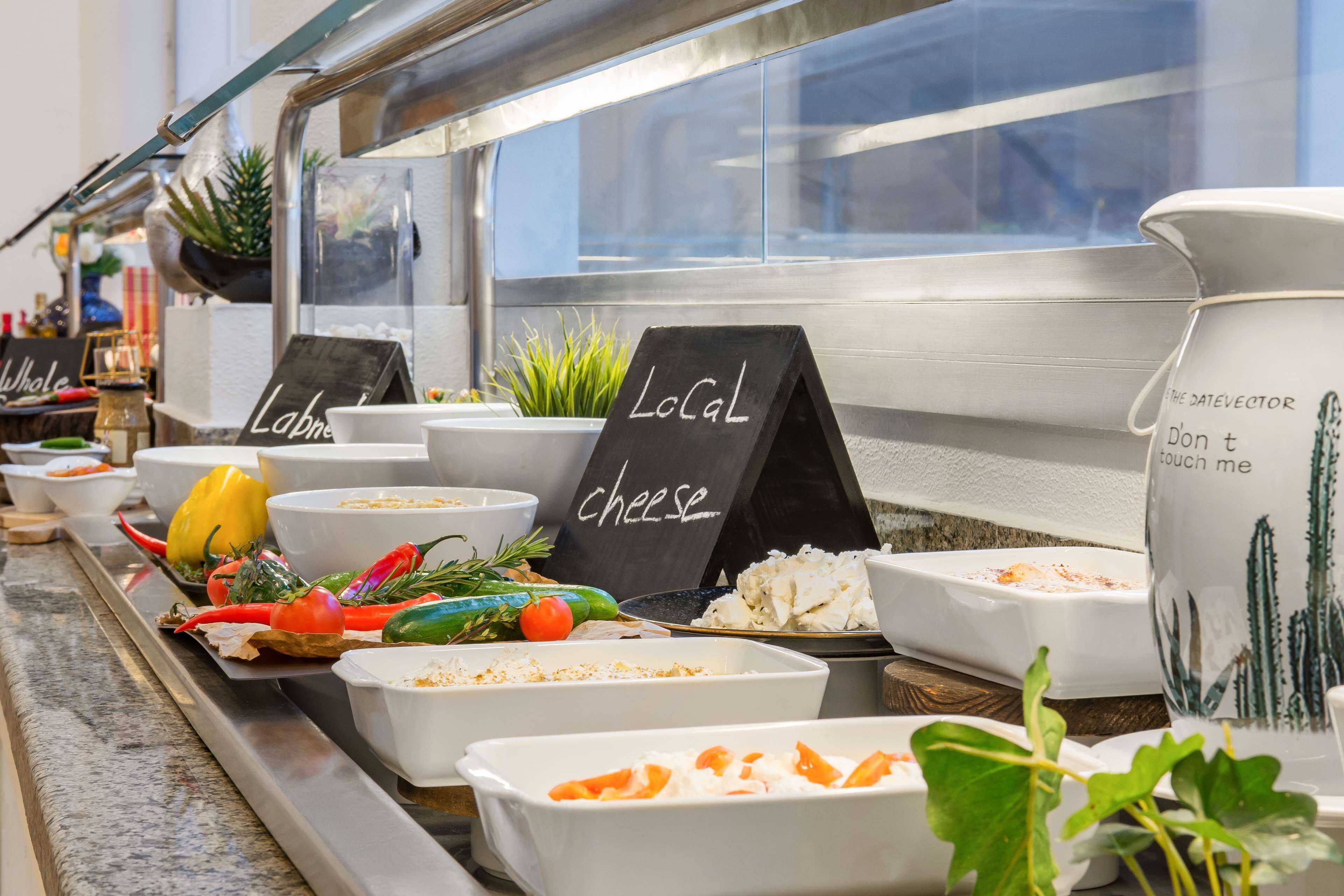 Un buffet proposant divers plats et une pancarte indiquant « Fromages de la région ».