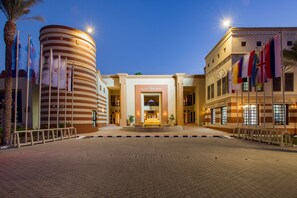 A hotel entrance with a central fountain, palm trees, and flags. - Marina Resort Port Ghalib Radisson Individuals (El Quseir)