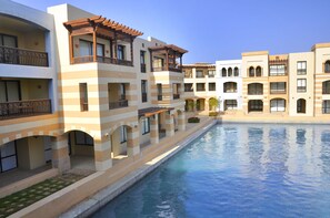 A hotel with multiple balconies, a swimming pool, and a courtyard. - Marina Resort Port Ghalib Radisson Individuals (El Quseir)