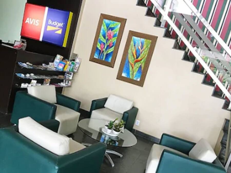 A lobby with green and white seating, a small table with plants, and a staircase.