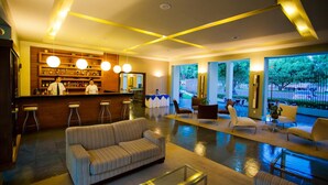 Een moderne lobby met een bar, zitplaatsen en grote ramen.