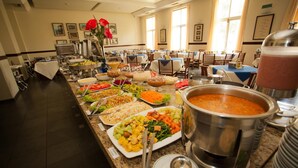 Een buffetopstelling met verschillende gerechten en een grote soeppot.