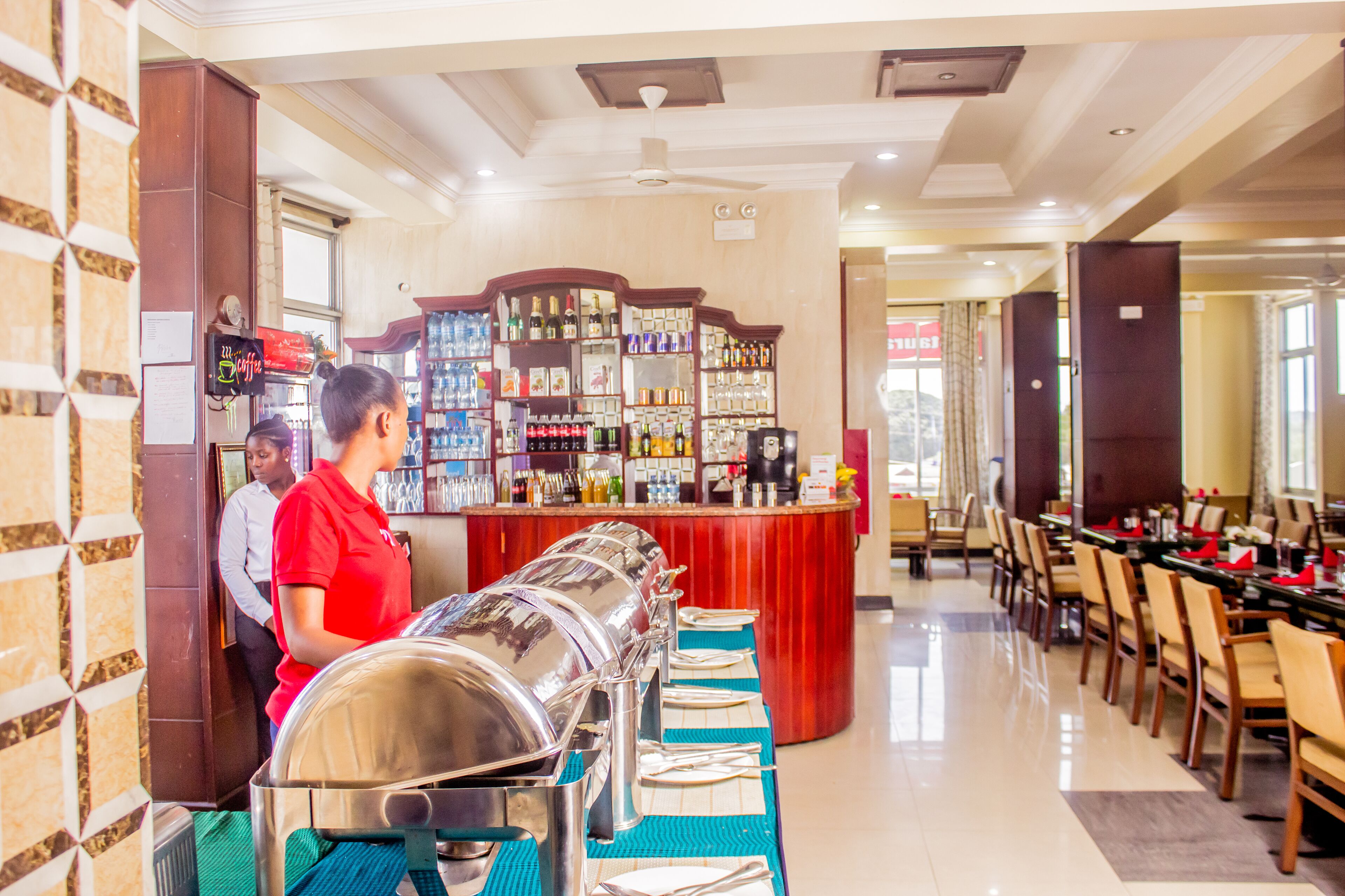 A buffet setup with a variety of food items and a bar area with beverages.