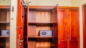 Ein begehbarer Kleiderschrank mit Holzböden und einem Safe.