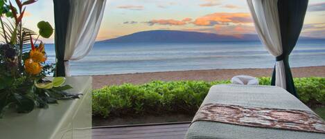 Una habitación con vista al mar, una cama y una planta.