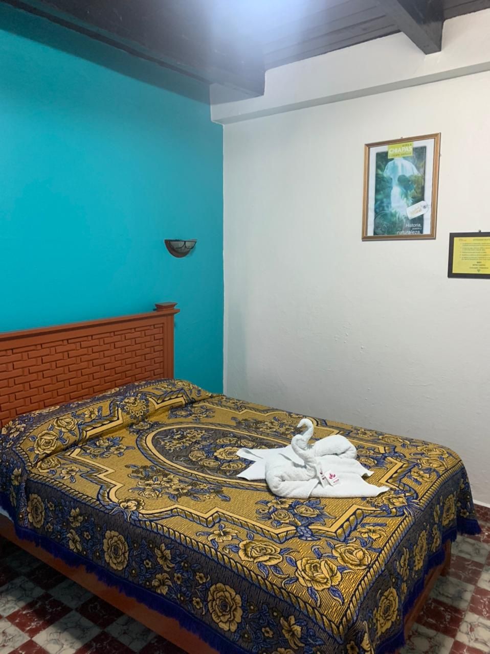 Una habitación con una cama, un reloj de pared y un cuadro enmarcado.