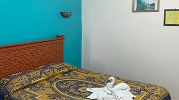 Una habitación con una cama, un reloj de pared y un cuadro enmarcado.