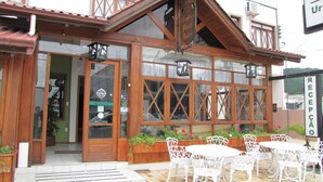 A wooden building with a reception area, outdoor seating, and a sign indicating a reception.