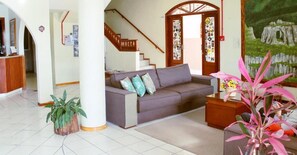 A living room with a sofa, a coffee table, and a plant.