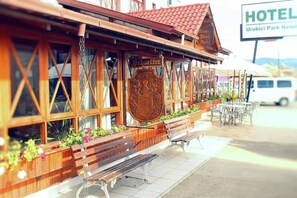 Un bâtiment en bois avec une enseigne indiquant « Hôtel » et « Urbici Park Hotel ».
