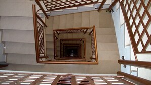 A spiral staircase with wooden railings and a lattice design. - Hotel Madrid (Pontevedra)
