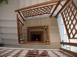 Una escalera de caracol con barandillas de madera y un diseño de celosía.