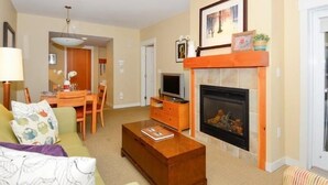 Una sala de estar con chimenea, comedor y ventilador de techo.