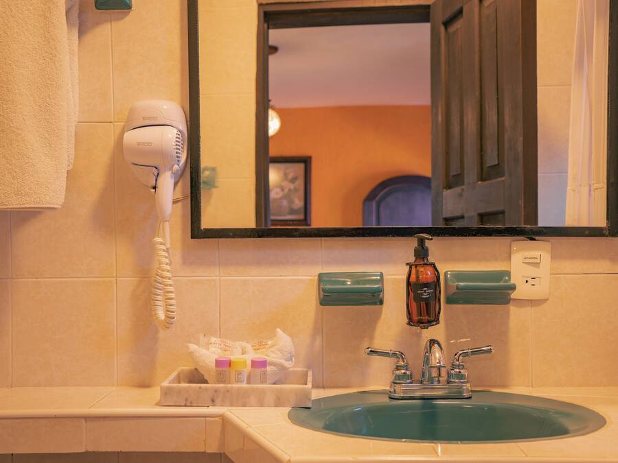 A bathroom with a sink, a hairdryer, and a mirror.