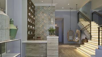 Un interior moderno con una escalera de madera, un sillón colgante y un estante decorativo con jarrones.