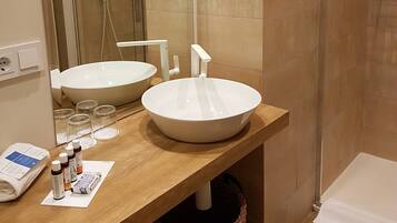 A bathroom with two sinks, a mirror, and a shower.