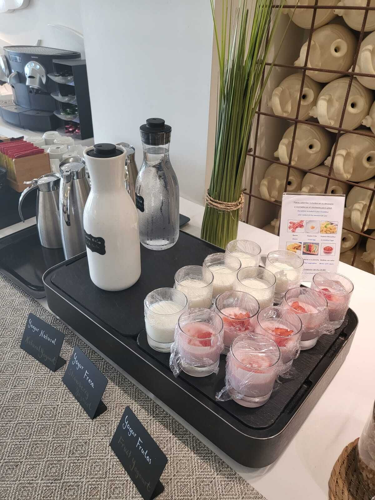 A tray with various dairy products, including yogurt and milk, and a coffee machine.