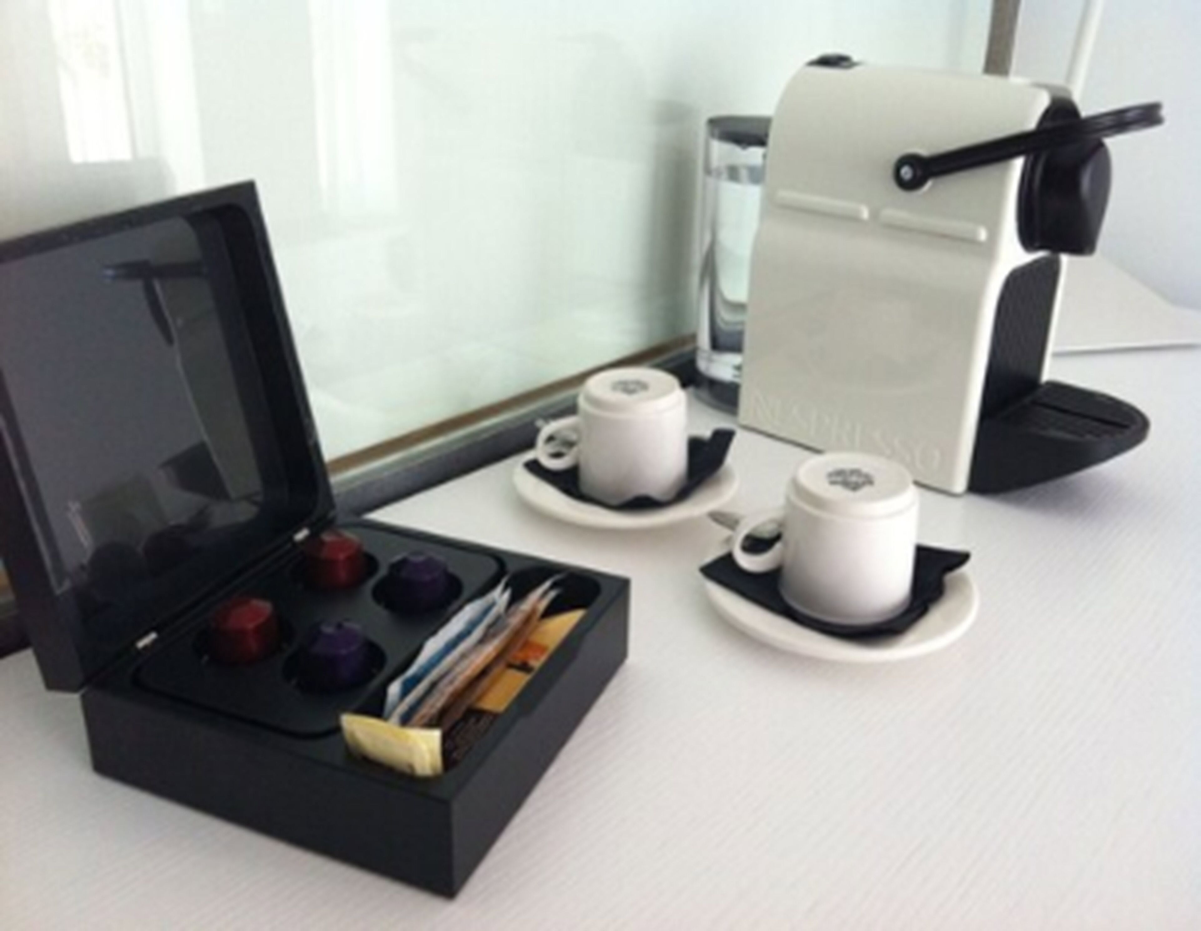 A coffee machine with a drip tray and a coffee pod holder.
