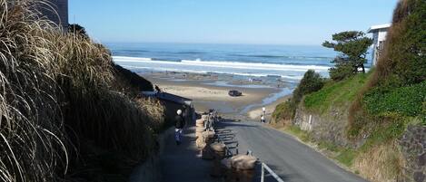 A coastal road leading to a beach with a clear view of the ocean.