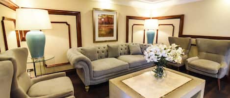 A modern living room with a sectional sofa, two armchairs, a coffee table, and two floor lamps.