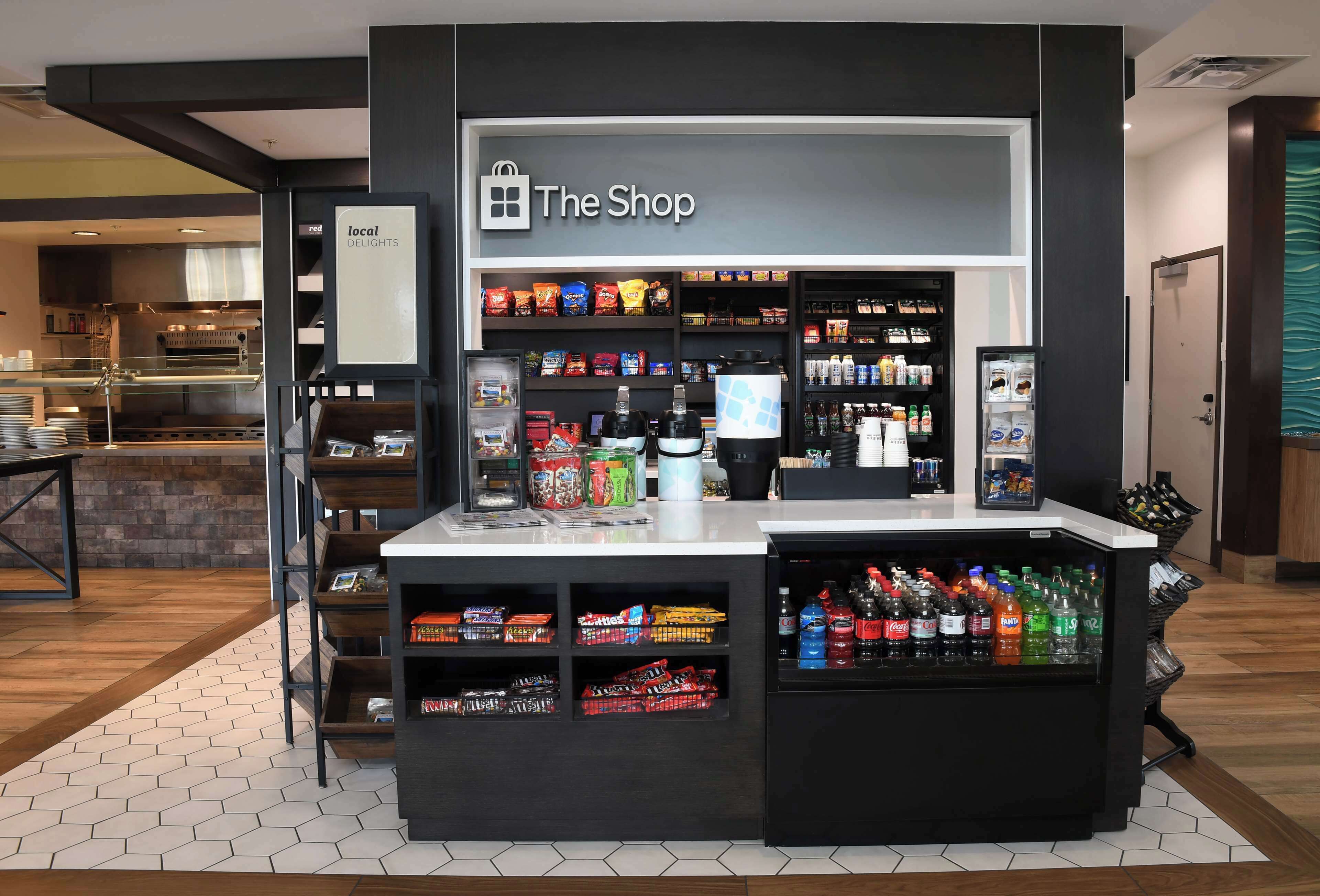 Una tienda de hotel con estantes llenos de aperitivos, bebidas y otros artículos.