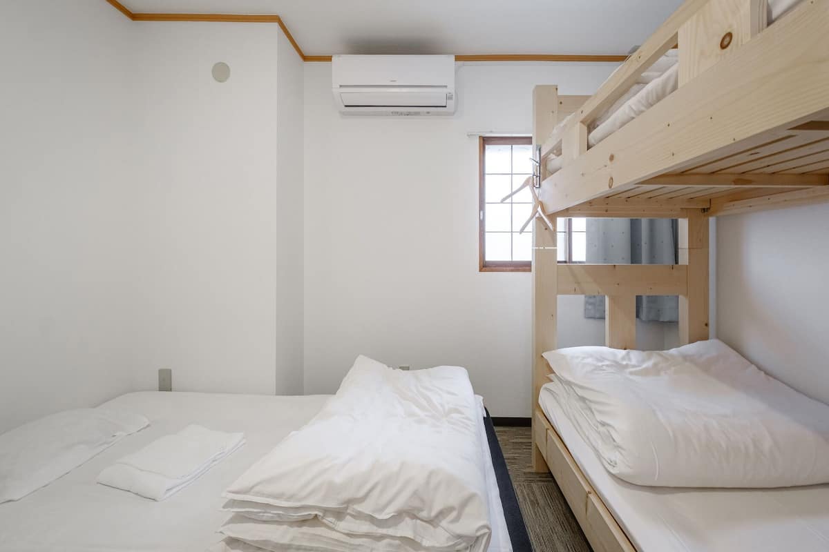 A bunk bed room with a single bed and a window.