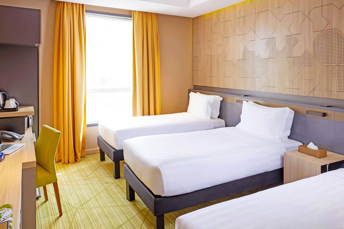 Una habitación de hotel con dos camas, un escritorio y una silla.