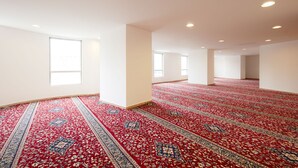 A spacious room with a patterned carpet, large windows, and recessed ceiling lights. - ibis Styles Makkah (Makkah)