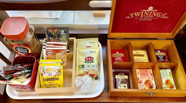 Variedad de productos de té y café, incluyendo Twinings de Londres, GreenMax y Té con Leche Mr. Brown, dispuestos en bandejas y cajas.