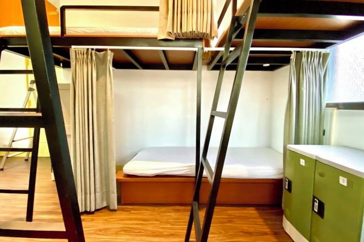 Habitación con literas, una mesita y un armario.