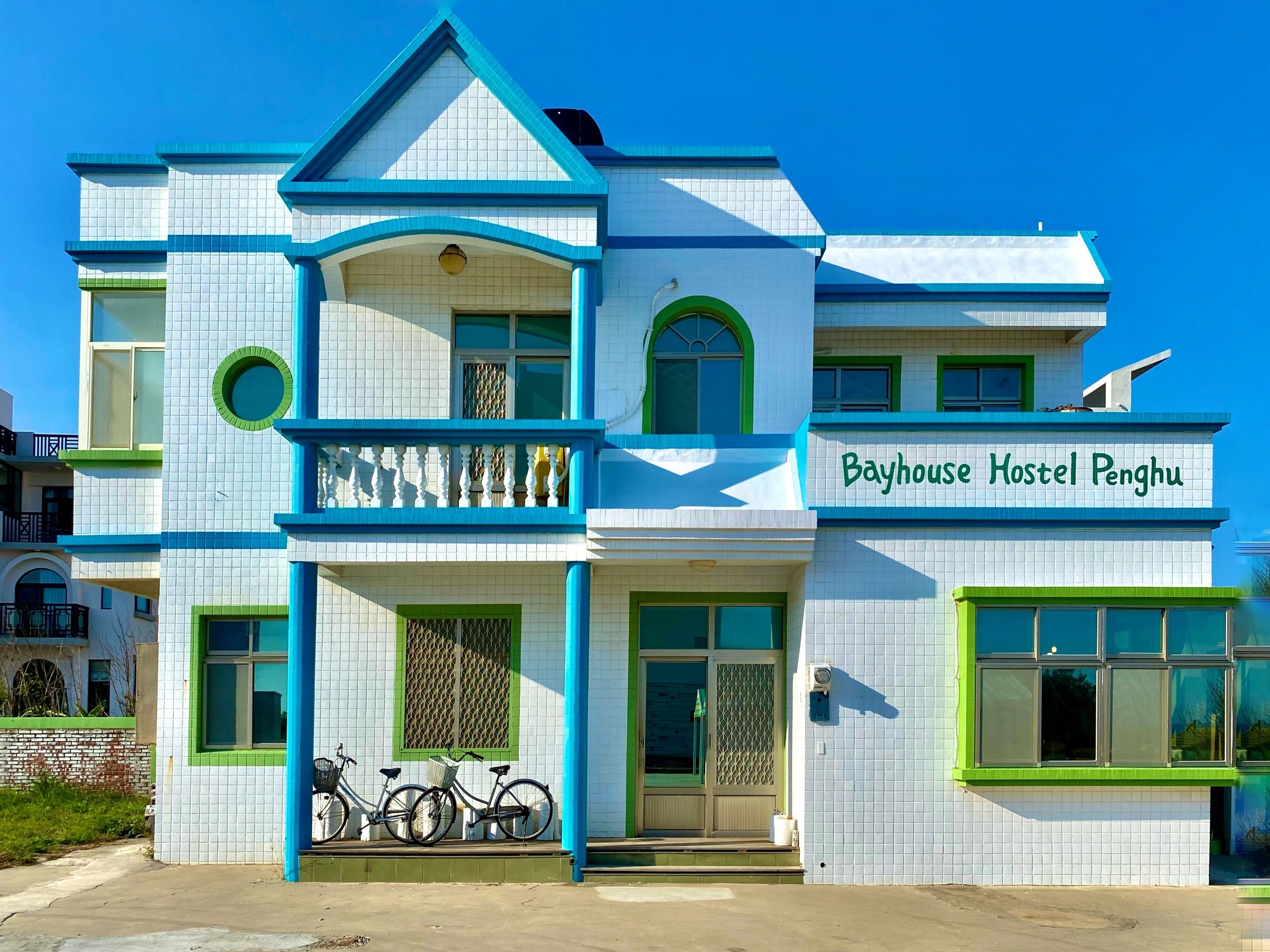 A two-story building with a sign reading "Bayhouse Hostel Penghu".