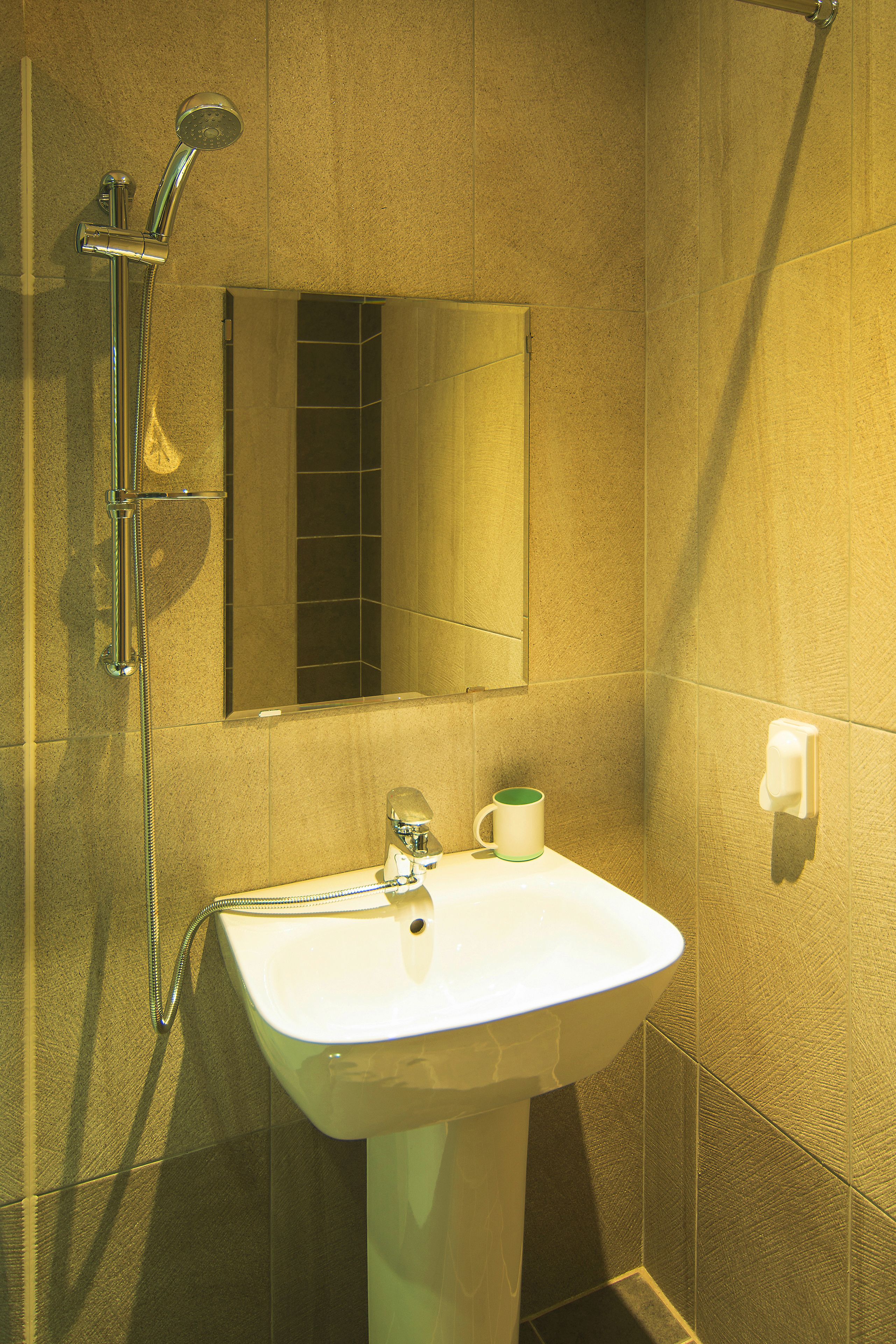 Un baño con lavamanos, espejo y ducha.