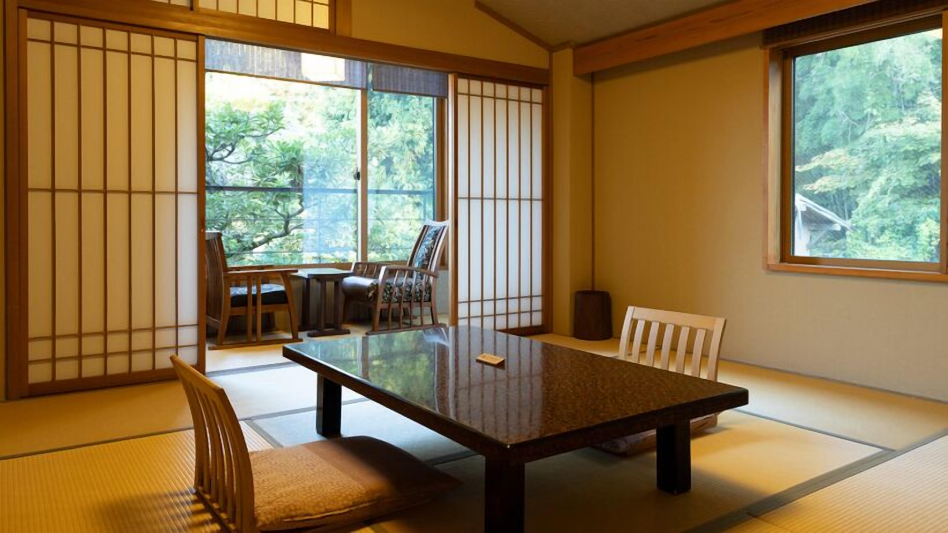 Um quarto japonês tradicional com tatames, uma mesa baixa e portas deslizantes.