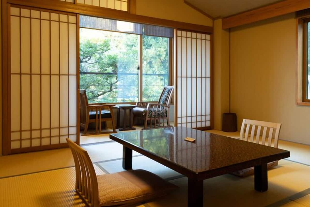 A traditional Japanese room with tatami flooring, a low table, and sliding doors.