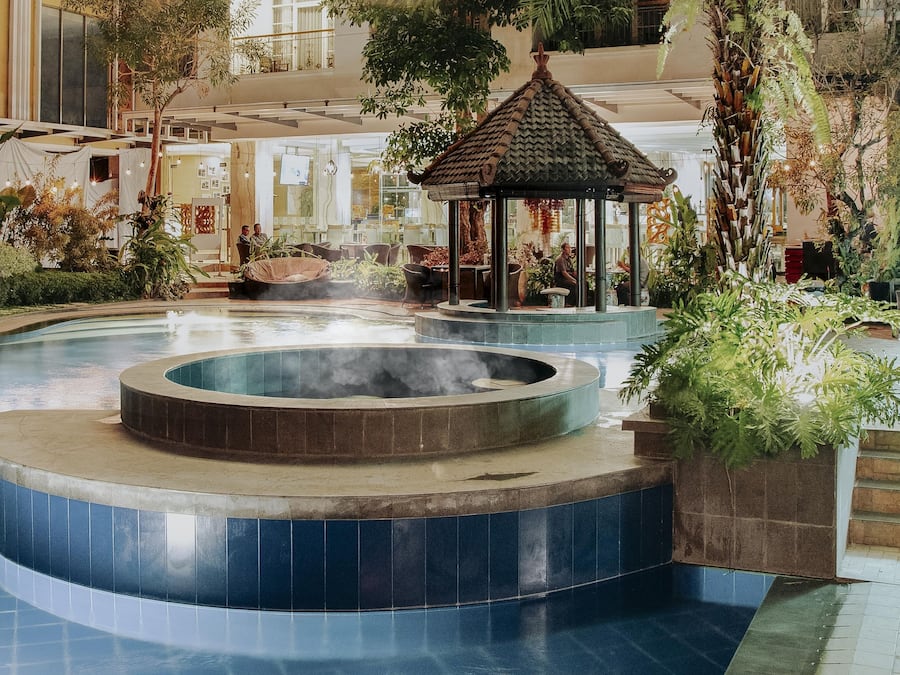 Una piscina al aire libre, sombrillas, sillones reclinables de piscina