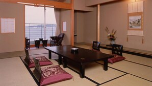 Une pièce de style japonais traditionnel, avec un sol recouvert de tatamis, une basse table en bois et des chaises.