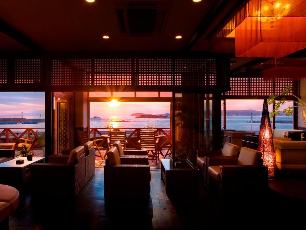A cozy lounge area with seating and a view of the sunset over the water.