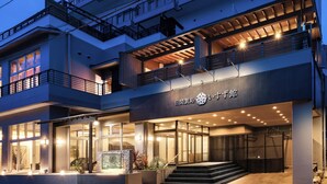 Un hôtel moderne doté d’une entrée imposante, de nombreux balcons et d’une façade bien éclairée.