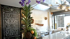 A kitchen with a chalkboard sign, a potted plant, and a marble countertop. - Papo'a Hotel (Kaohsiung)