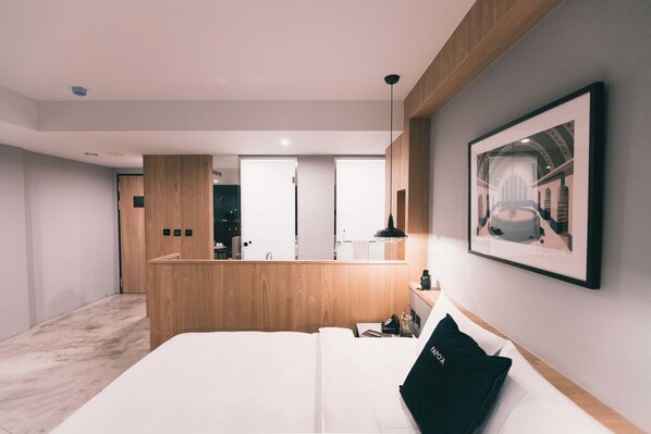 Et moderne hotelværelse med en stor seng, et træskrivebord og et spejl.