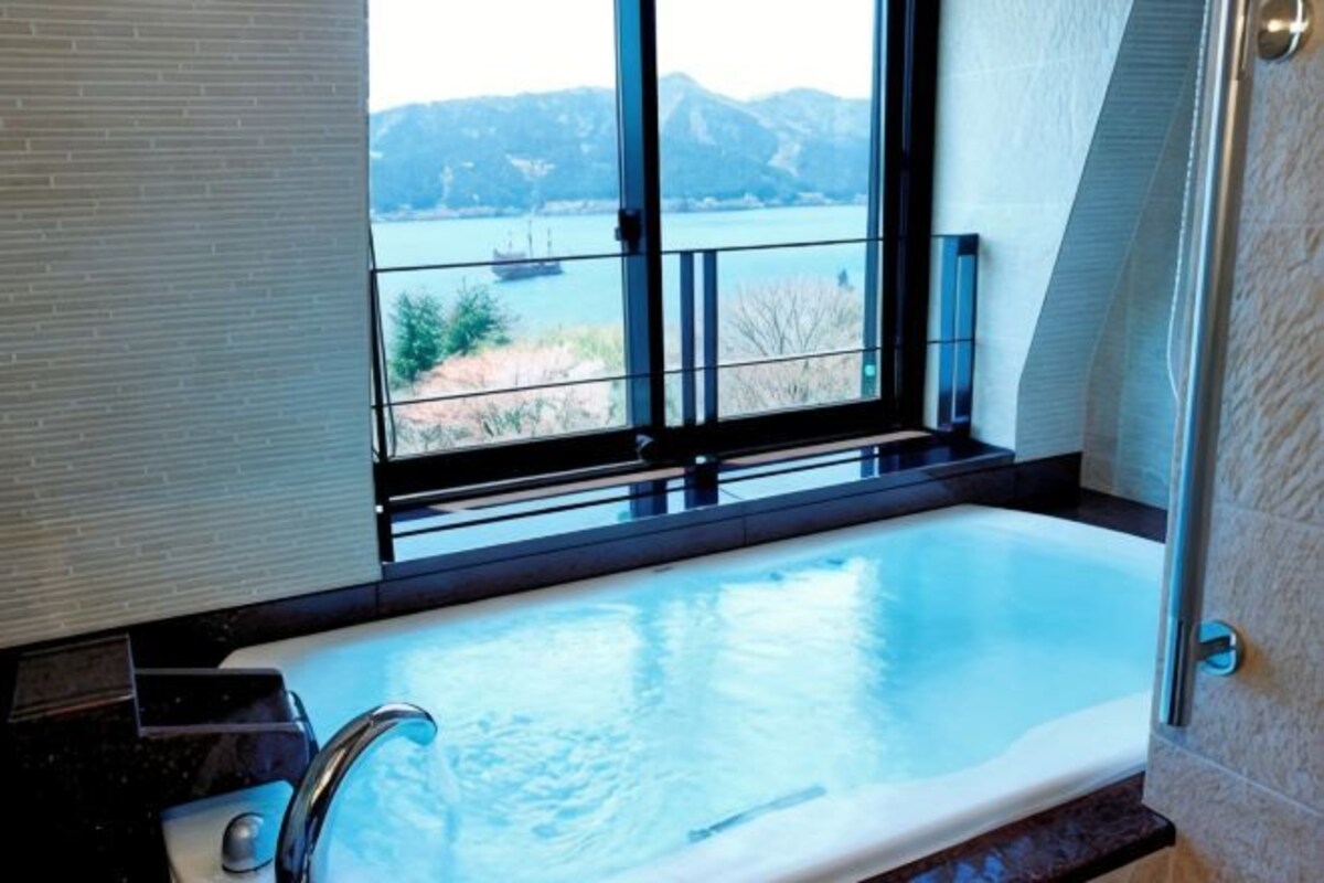 Una bañera con vistas a un lago y montañas.