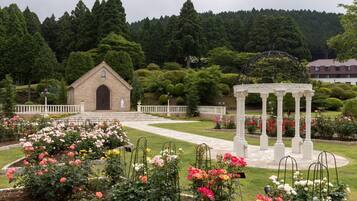 Ein Garten mit einem Gartenhäuschen, einem kleinen Backsteinbau und einem gepflegten Rasen.