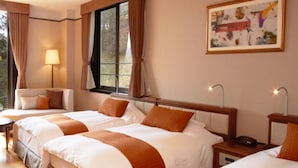 A hotel room with three beds, a sofa, a lamp, and a painting on the wall. - Odakyu Hotel de Yama (Hakone)